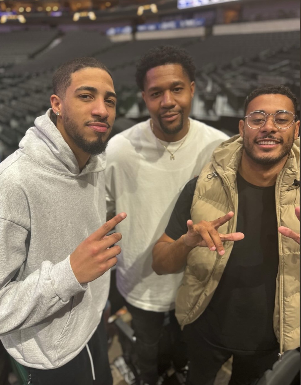 Troy courtside at an arena with friends